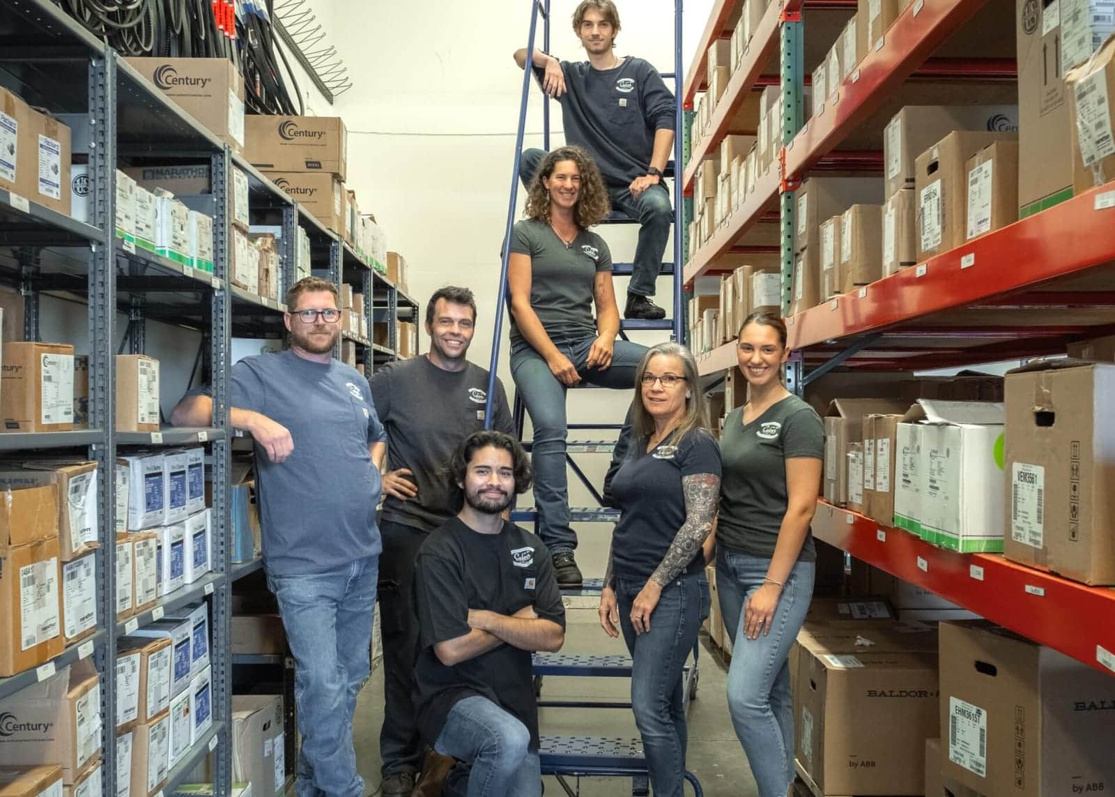 The Culver Pump & Motor team in the parts warehouse aisle, surrounded by shelves of stocked motors