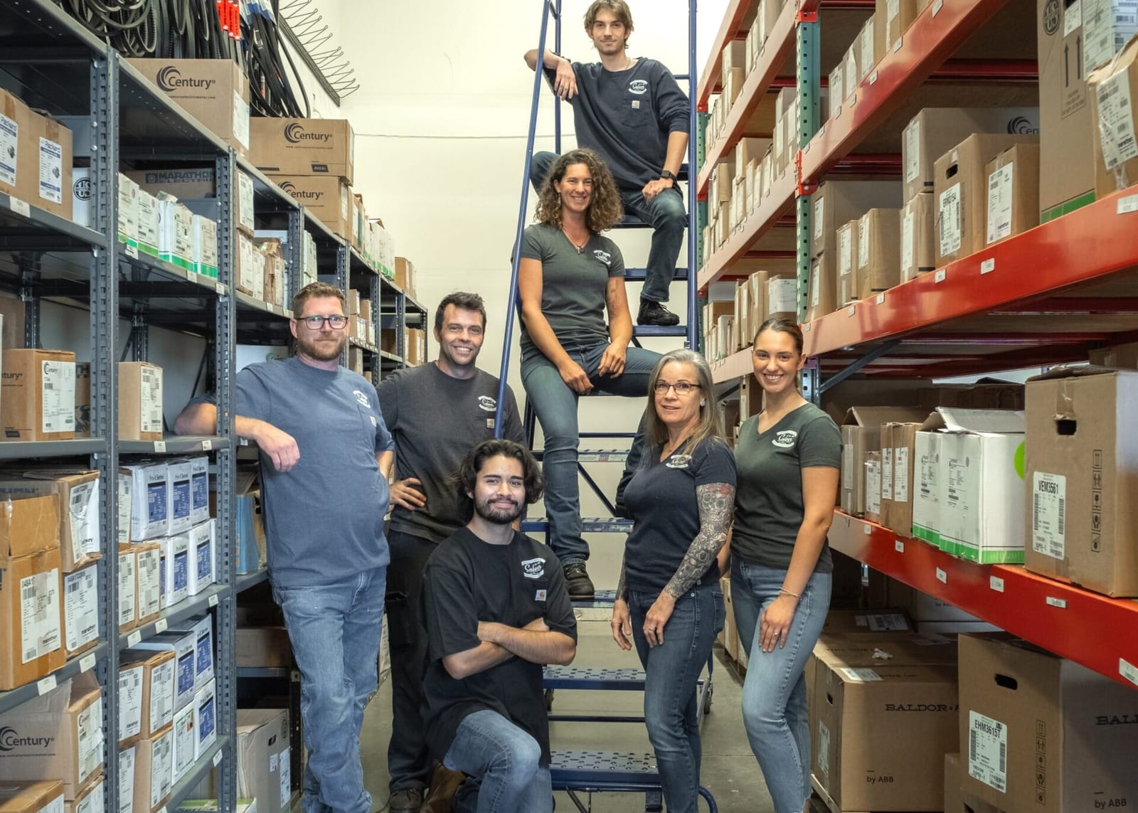 The Culver Pump & Motor team in the parts warehouse aisle, surrounded by shelves of stocked motors